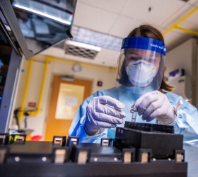 Researcher working in lab wearing protective gear 